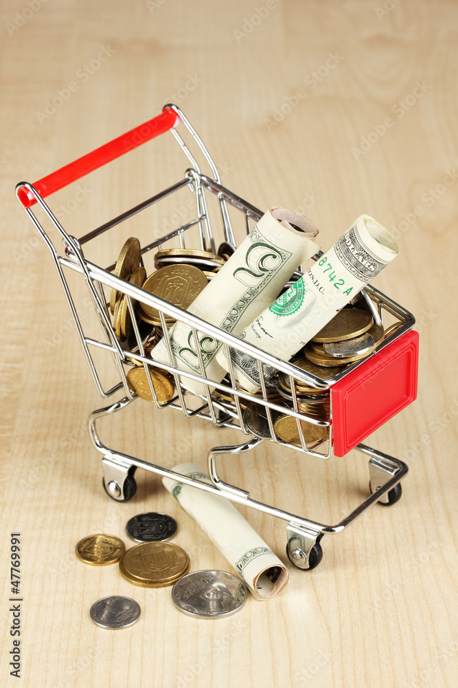 Money in cart on wooden table close-up