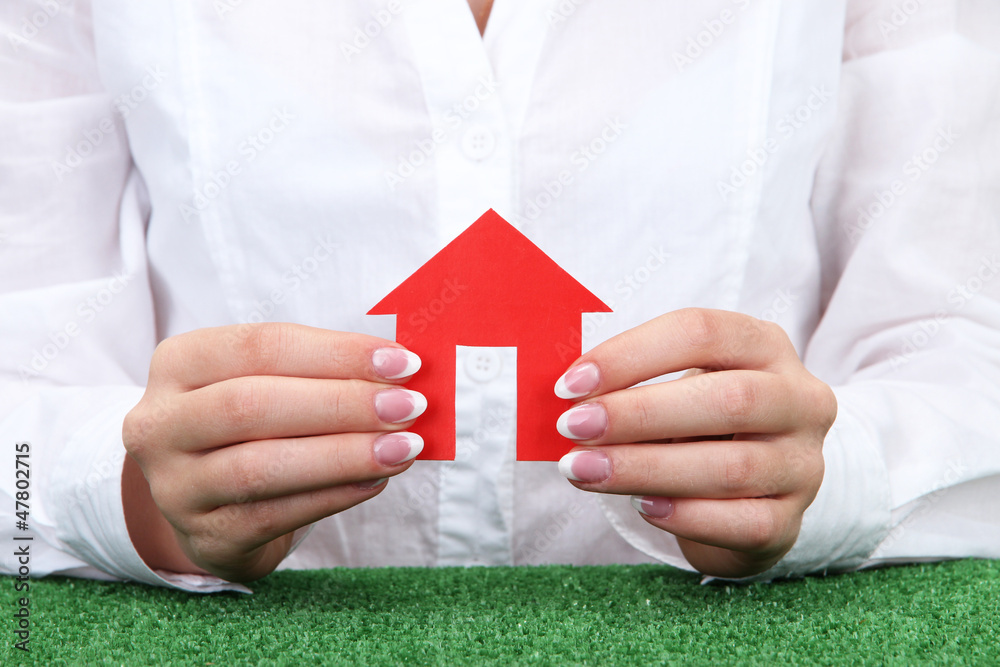 concept: woman hands with paper house, close up