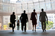 Employees going against the office. Panorama. Silhouettes.
