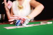 © Peter Atkins - Frau schiebt Jetons in Pokertisch