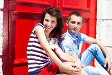 Couple In Love Osing On The Background A Bright Red Door