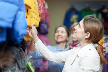 family chooses winter wear at clothes store