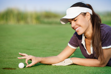 Woman pushing golf ball