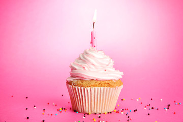 Wall Mural - tasty birthday cupcake with candle, on pink background