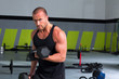 © lunamarina - Gym man with dumbbells exercise crossfit