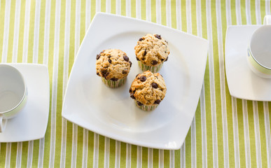 Wall Mural - Chocolate chip muffins on white plate and green striped tableclo