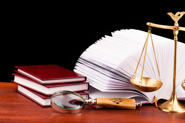 books of justice and scale on wooden table