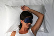 © Gustavo Andrade - Mujer durmiendo descansando con tapa ojos.en una cama