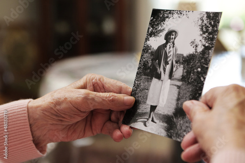 Fotografía Seniorin mit altem Foto aus ihrer Jugend