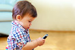 © Olesia Bilkei - curious baby toddler exploring mobile phone