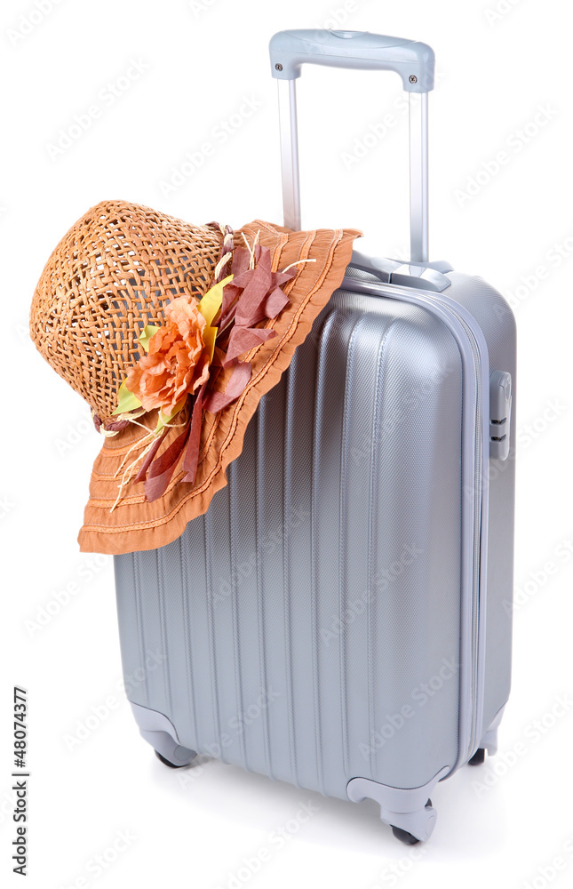 Silver suitcase with woman's hat  isolated on white