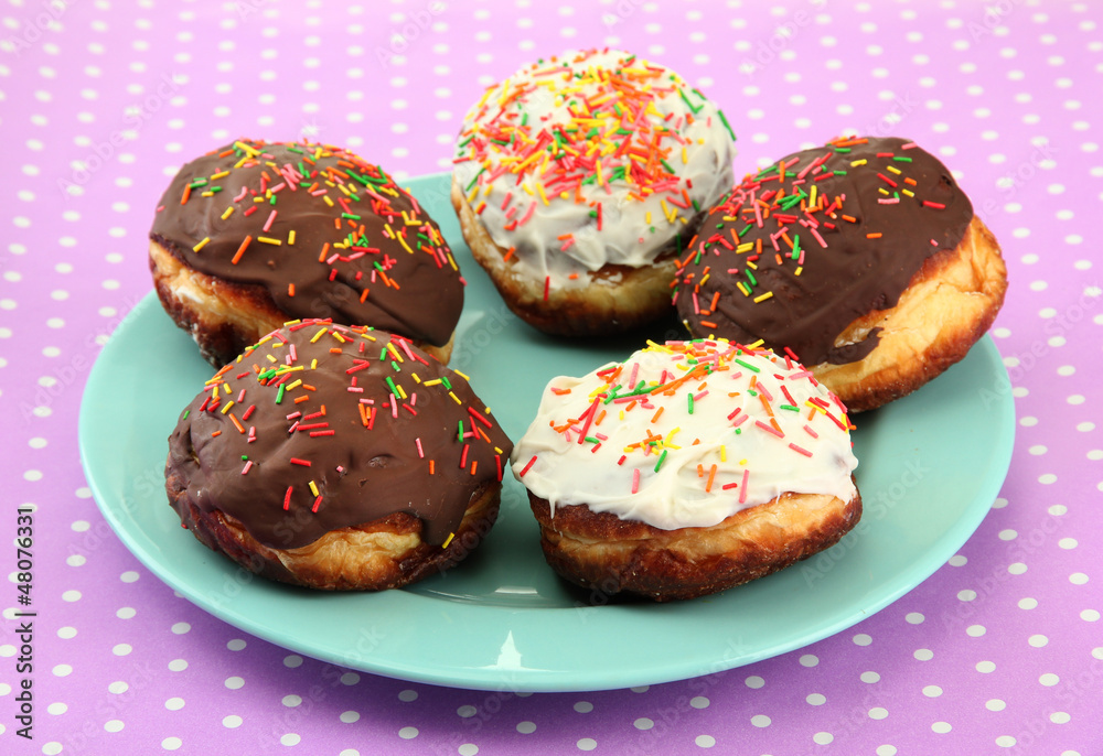 Tasty donuts on color plate on color background