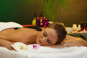 Wall Mural - beautiful young woman in spa salon with spa stones,