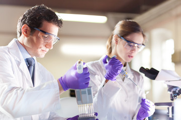 Poster - Attractive young scientist pipetting.