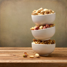Assorted Nuts In Dishes On Wooden Table