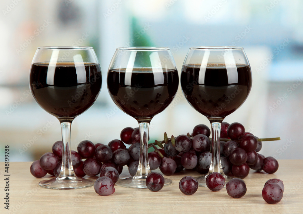 Red wine in glass on room background