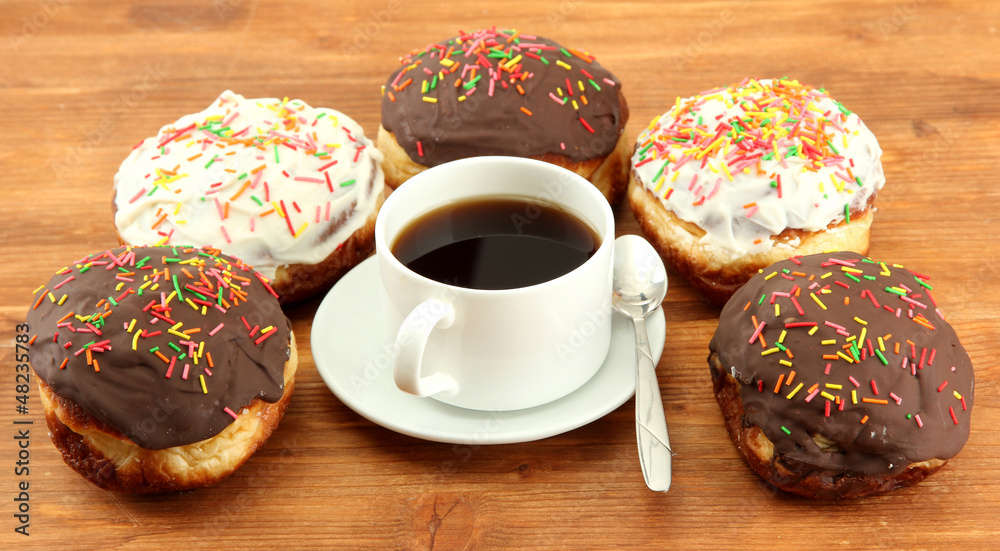 Tasty donuts on color plate on wooden background