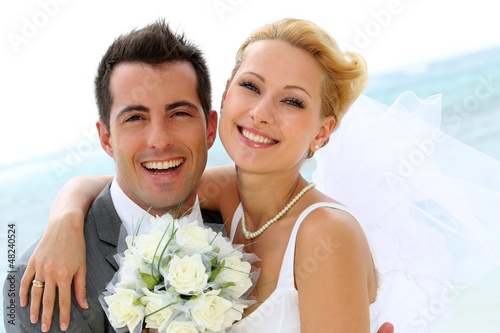 Fotografía Cheerful married couple standing on the beach