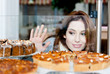 © Karramba Production - Lady  looking at the bakery window full of cakes