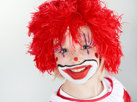 Beautiful child as a funny clown with red hair