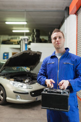 Poster - Confident auto mechanic with car battery