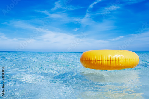 Foto Rollo Basic - floating yellow ring on crystal blue sea water with sky, shallow (von Elena Moiseeva)
