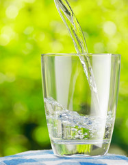 Sticker - Glass of water on nature background