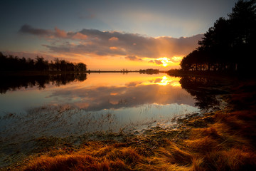 Fototapete - dramatic and silent sunset on lake