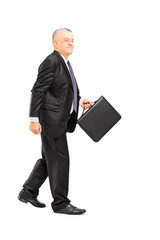 Wall Mural - Full length portrait of a mature businessperson briefcase walkin