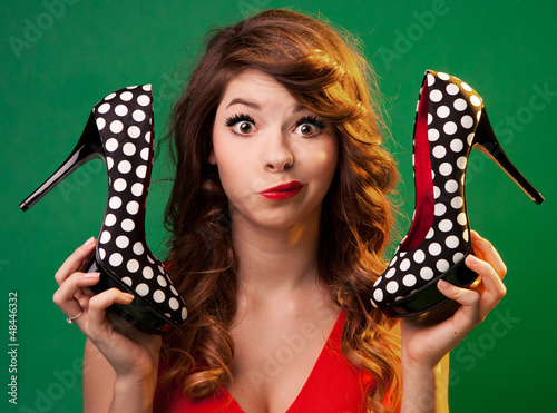 Fotografia Funny young woman holding high heels shoes