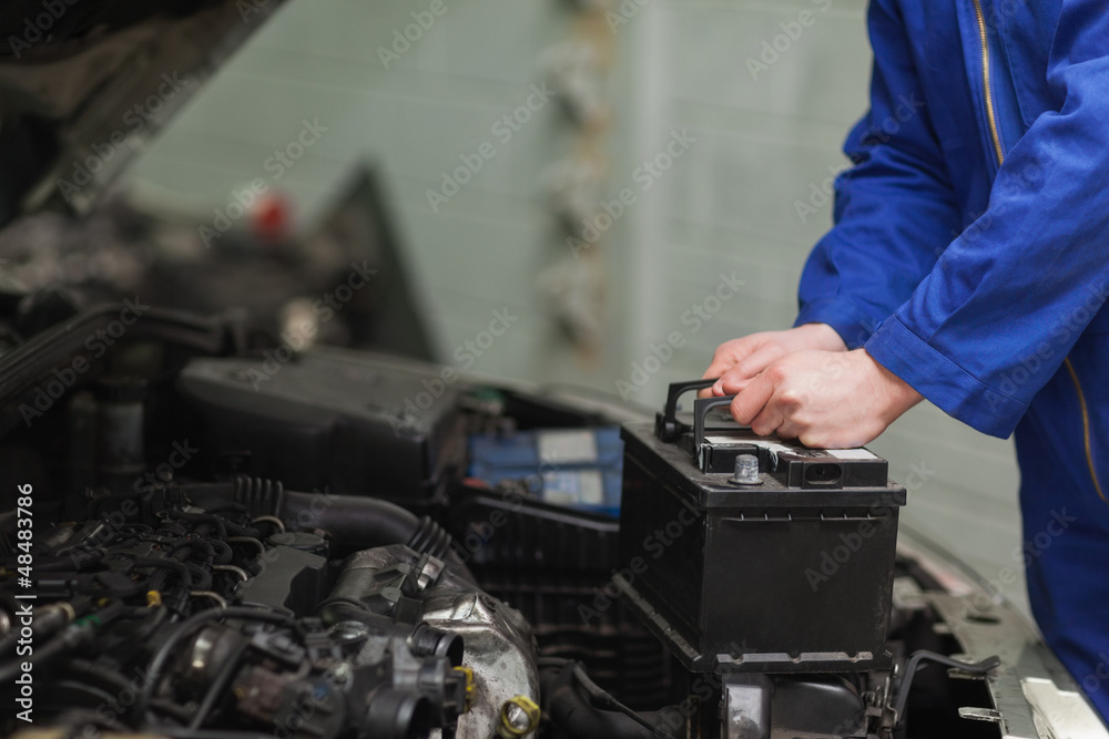 Mechanic changing car battery - obrazy, fototapety, plakaty 