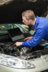 Poster - Repairman with laptop checking car engine