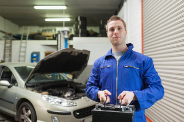 Poster - Mechanic carrying car battery