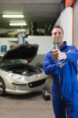 Poster - Male mechanic showing spanner