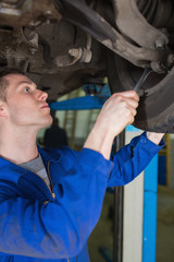 Poster - Man adjusting car tire with spanner