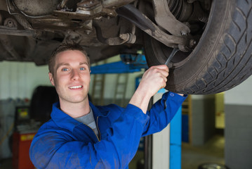 Poster - Mechanic repairing car with spanner