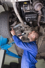 Poster - Auto mechanic examining under car