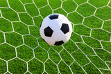Fototapeta Młodzieżowe - soccer ball in goal net