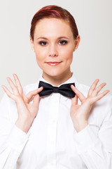 Wall Mural - elegant young waitress holding on to bow tie