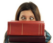 Female student with eyes crossed looking over stack of books
