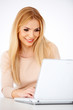© Dash - Happy blonde woman working on a laptop