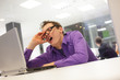 © endostock - bored yawning businessman with laptop in the office