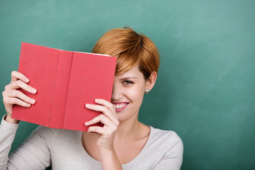 Wall Mural - junge frau mit buch vor der tafel