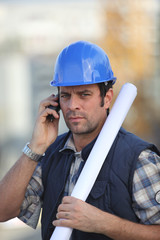 Wall Mural - Construction worker on site with a phone