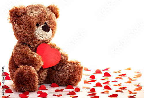 Fototapeta na wymiar Lonely teddy bear with heart in a paws