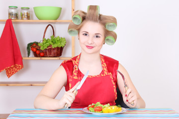 Wall Mural - young housewife eating in the kitchen