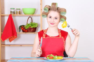 housewife eating vegetables in the kitchen