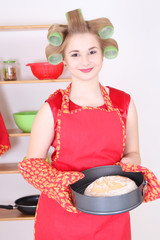 Wall Mural - young housewife with bread in the kitchen