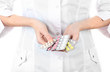© Africa Studio - Close-up of female doctor hand holding pills, isolated on white