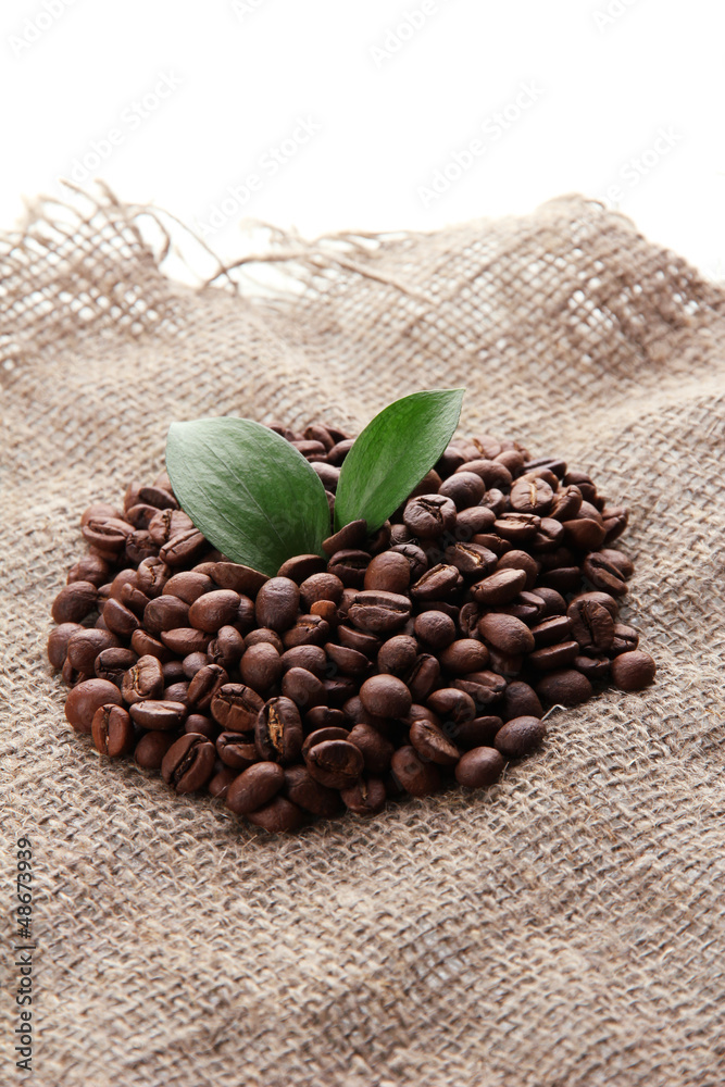 Coffee beans with leaves on sack-cloth background